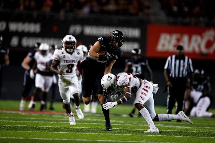 Cincinnati Bearcats tight end Josh Whyle (81) is ta led by Temple Owls safety M.J. Griffin (28) in the second half of the NCAA football game on Friday, Oct. 8, 2021, at Nippert Stadium in Cincinnati. Cincinnati Bearcats defeated Temple Owls 52-3. Temple Owls At Cincinnati Bearcats